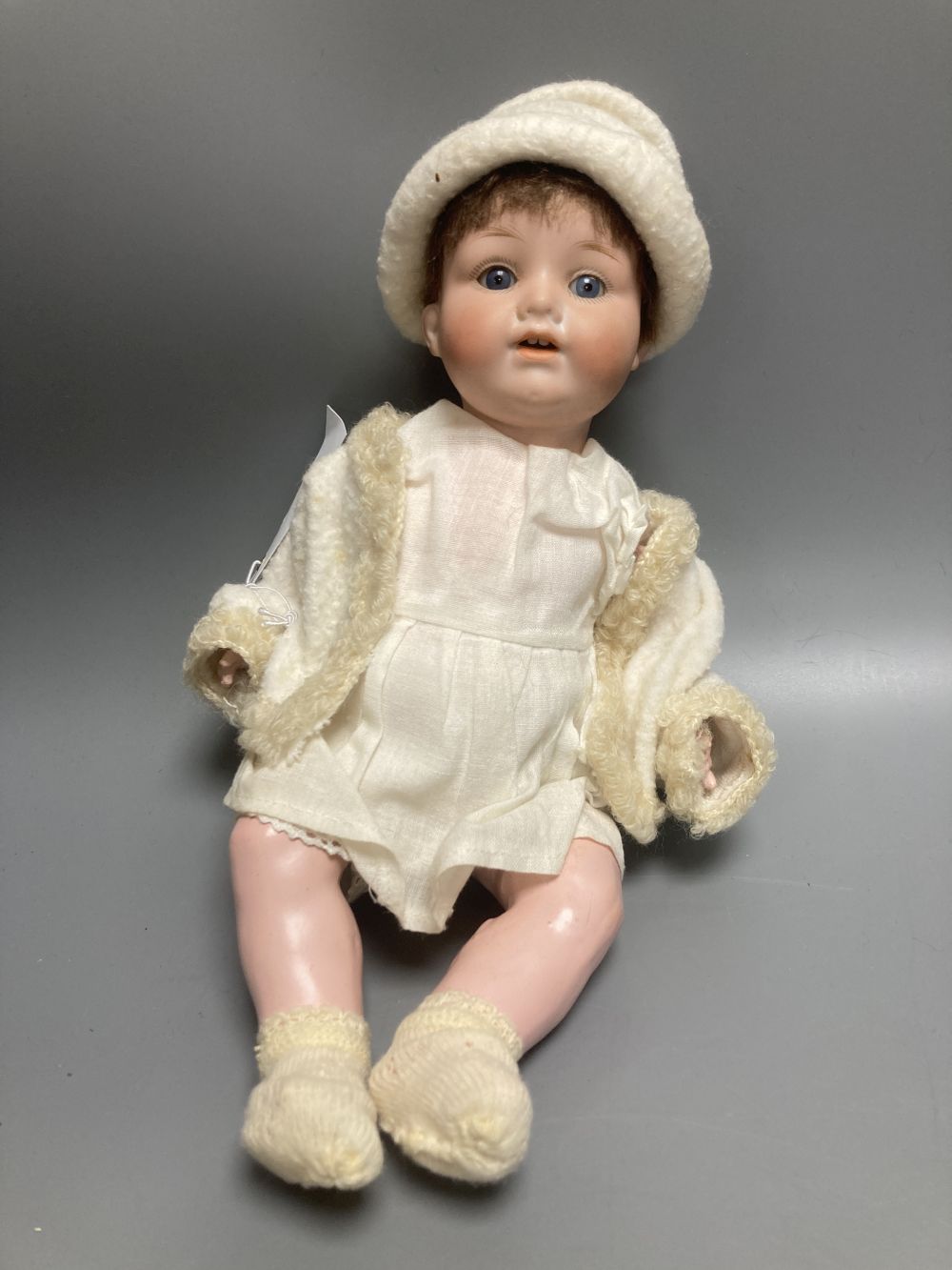 An Armand Marseille bisque boy doll, mould 990 with fixed glass eyes, 30cm, a bisque doll with jointed composition body, 47cm and a pai